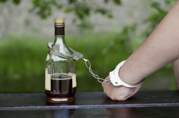 Бутылка и рука в наручниках